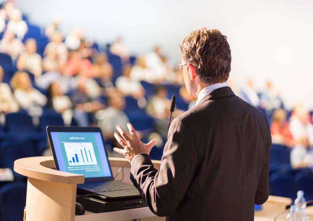 A man showing polling results to the audience during a scientific meeting.