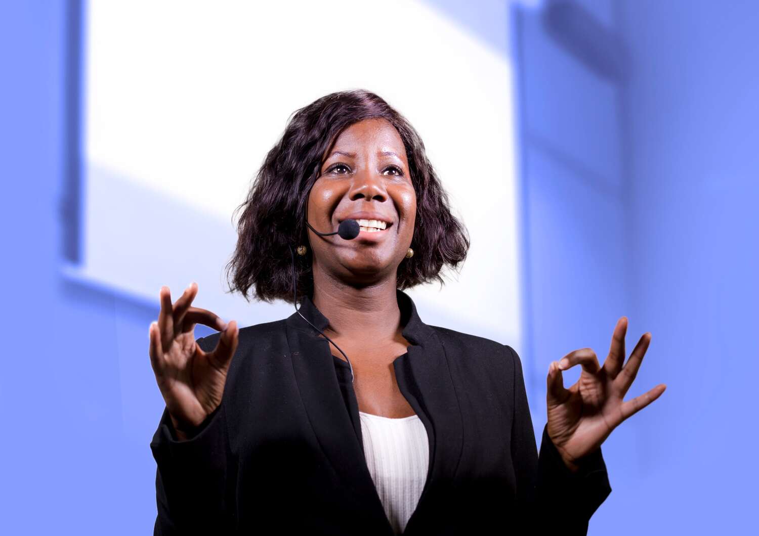 A black woman giving a talk during a scientific meeting.