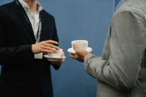 Two conference attendees sharing a conversation over coffee at a meeting supported by CTI Meeting Technology.